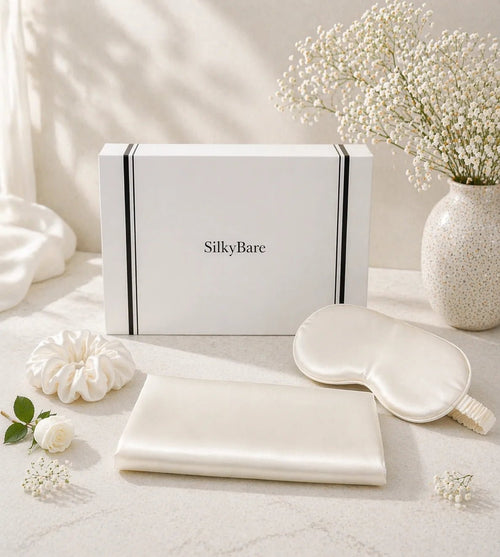 SilkyBare Luxury Mulberry Silk Gift Set with ivory silk pillowcase, eye mask and scrunchie beside a white gift box