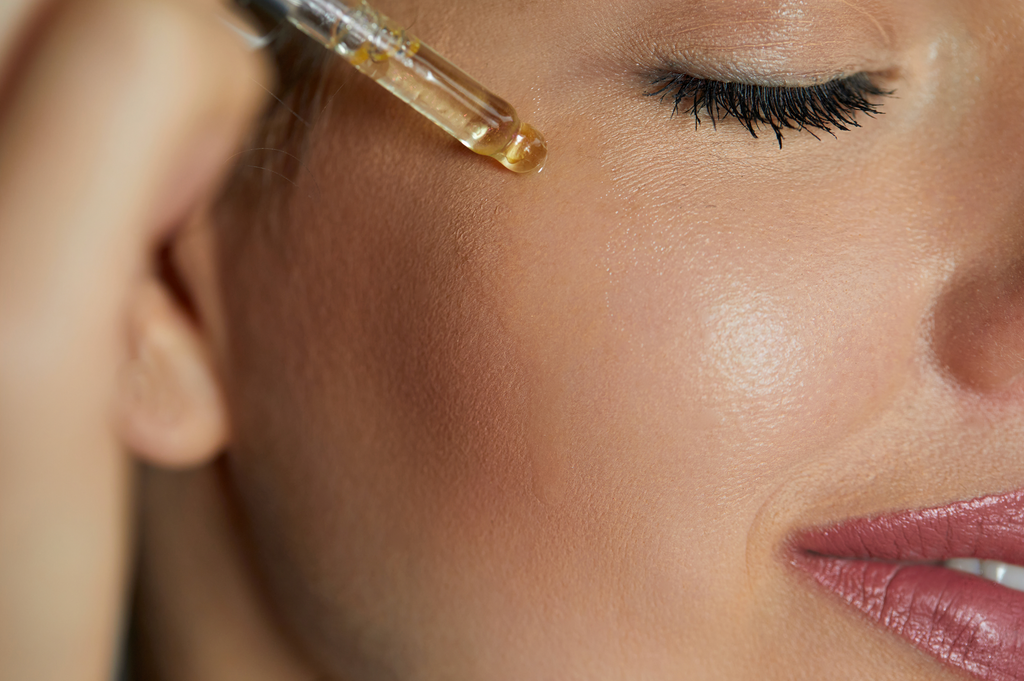 woman using face oil with natural ingredients on her face