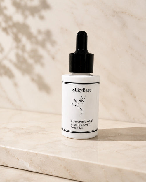 SilkyBare Hyaluronic Acid Serum 30ml dropper bottle on a white marble surface — lightweight gel serum with four forms of hyaluronic acid, made in Australia