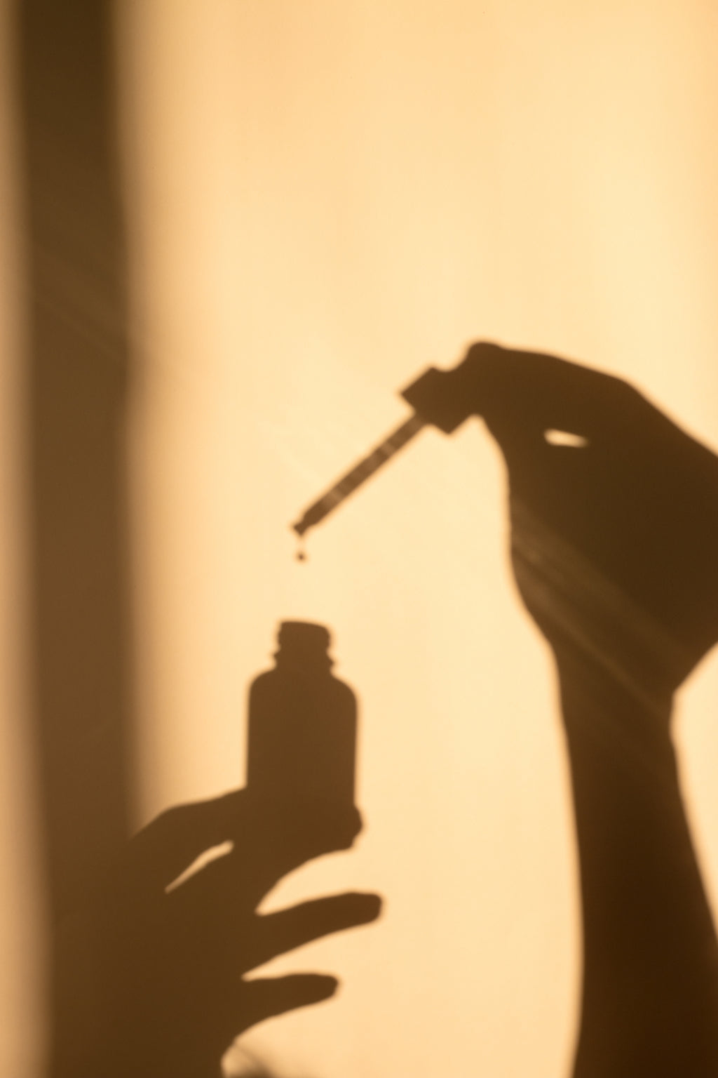 shadow of serum bottle with hand